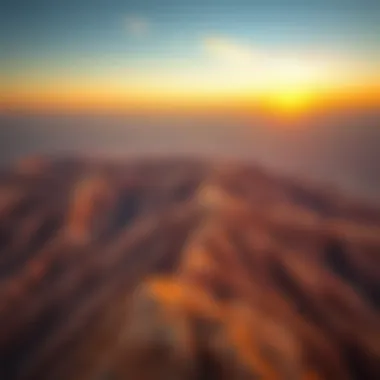 An aerial view of Jebel Hafeet mountain showcasing its rugged terrain and stunning sunset